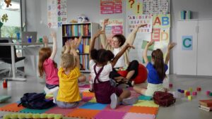 Elementary,School,Teacher,Sit,In,Class,On,Floor,With,Little