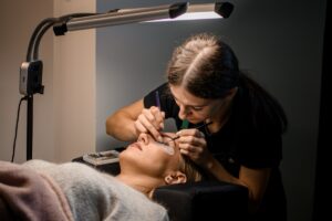 Professional,Woman,Beautician,Makes,Eyelash,Extension,For,Female,Client,In