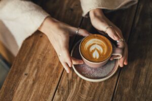 Woman,Drinking,Coffee,Sitting,By,The,Textured,Wooden,Table.,Close