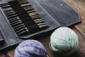 Locally Handmade knitting needles and yarn on a wooden table